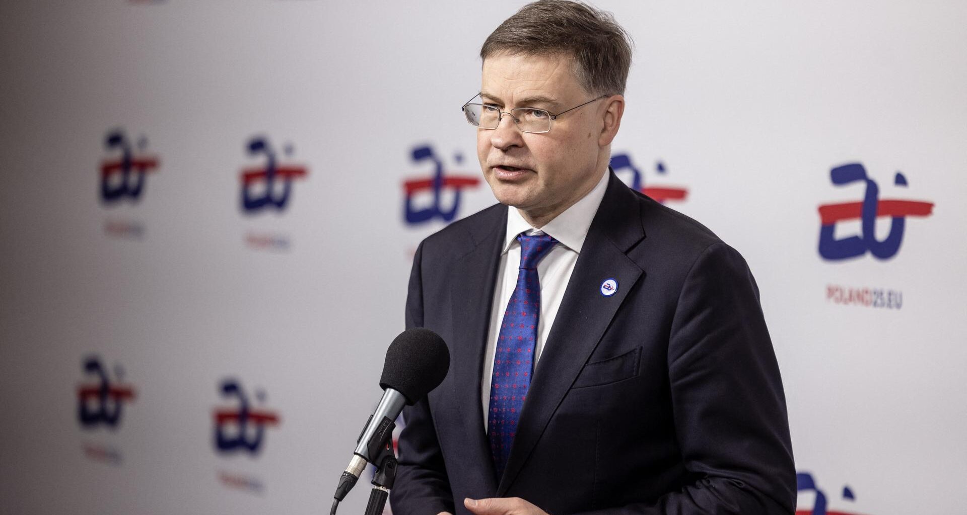 EU-Wirtschaftskommissar Dombrovskis steht hinter einem Mikrofon.