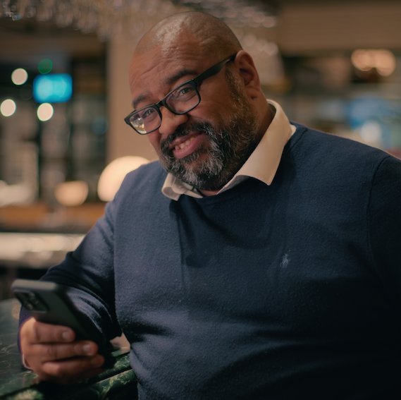graham sat at a bar holding his phone talking about being conned by his mum dionne