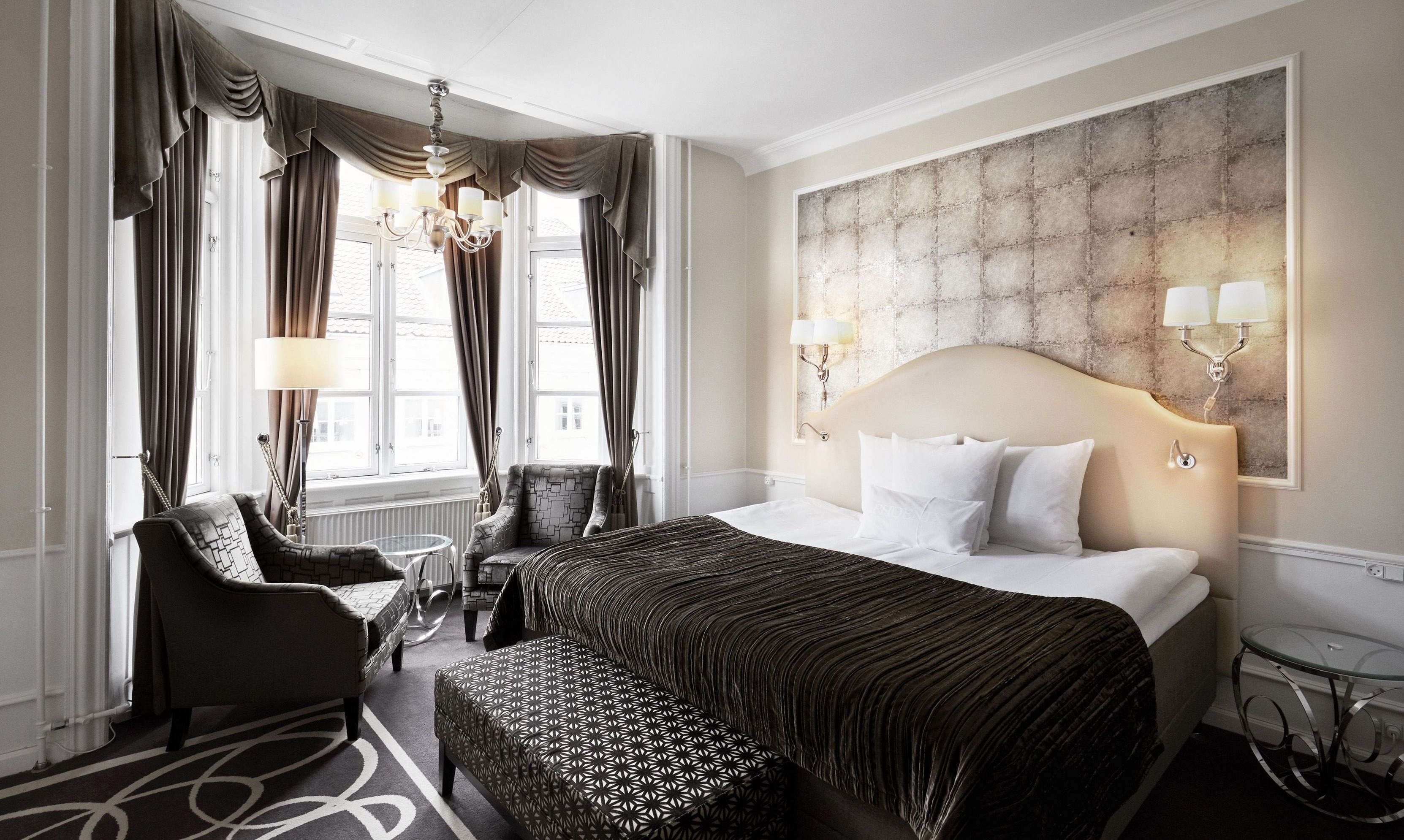 Hotel room with large bed and bay window.