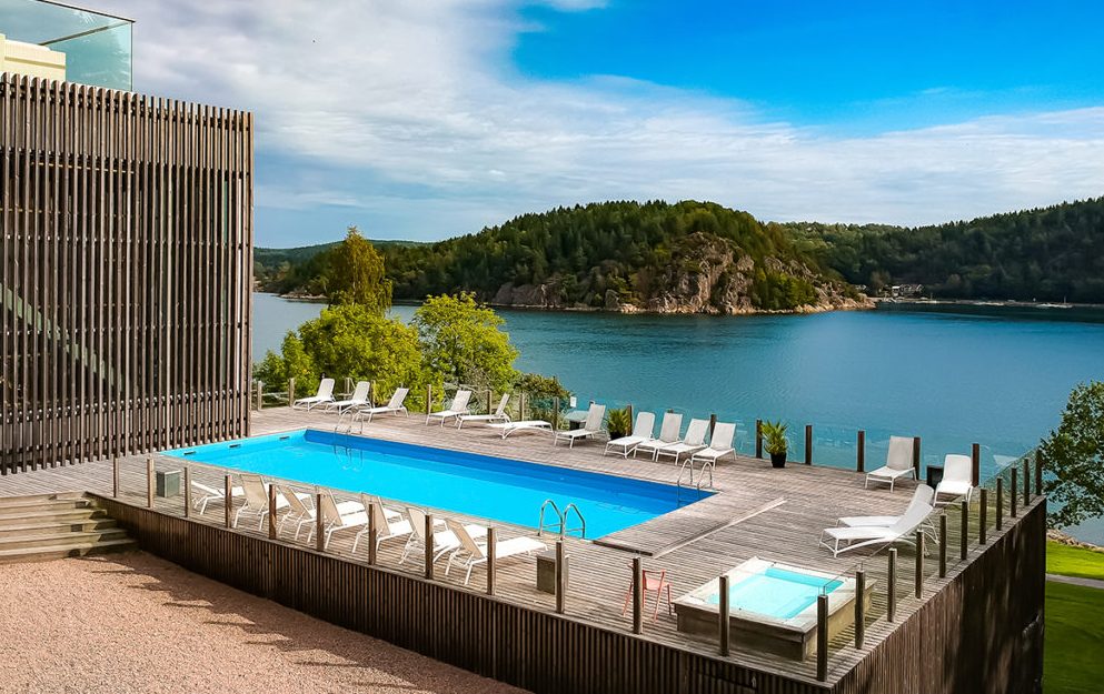 Hotel pool and hot tub overlooking a lake.