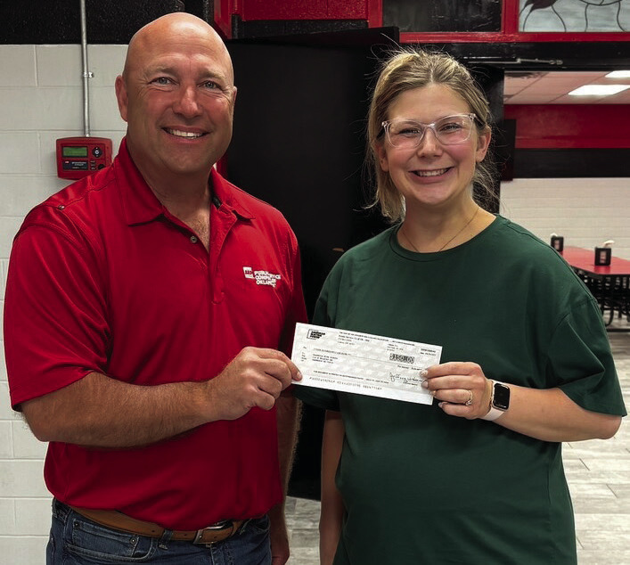 Kalley Hurt, a Carnegie High School science teacher, receives a $150 check from representative Mike Hixson