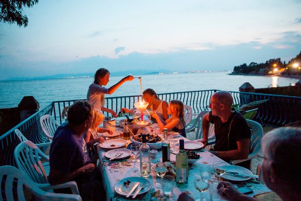 Family eating al fresco in evening, Sardinia