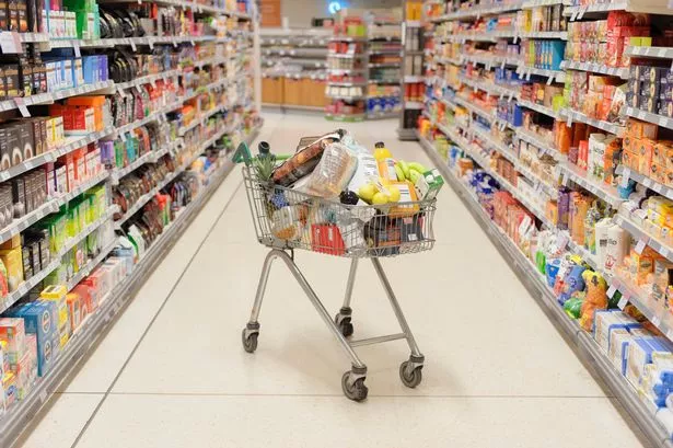 Full shopping cart in supermarket aisle
