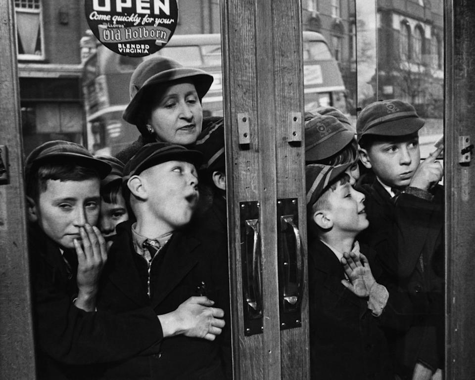 Young British boys line up before the local stores can open to wait for for candy, which is no longer being rationed. (Photo by © Hulton-Deutsch Collection/CORBIS/Corbis via Getty Images)