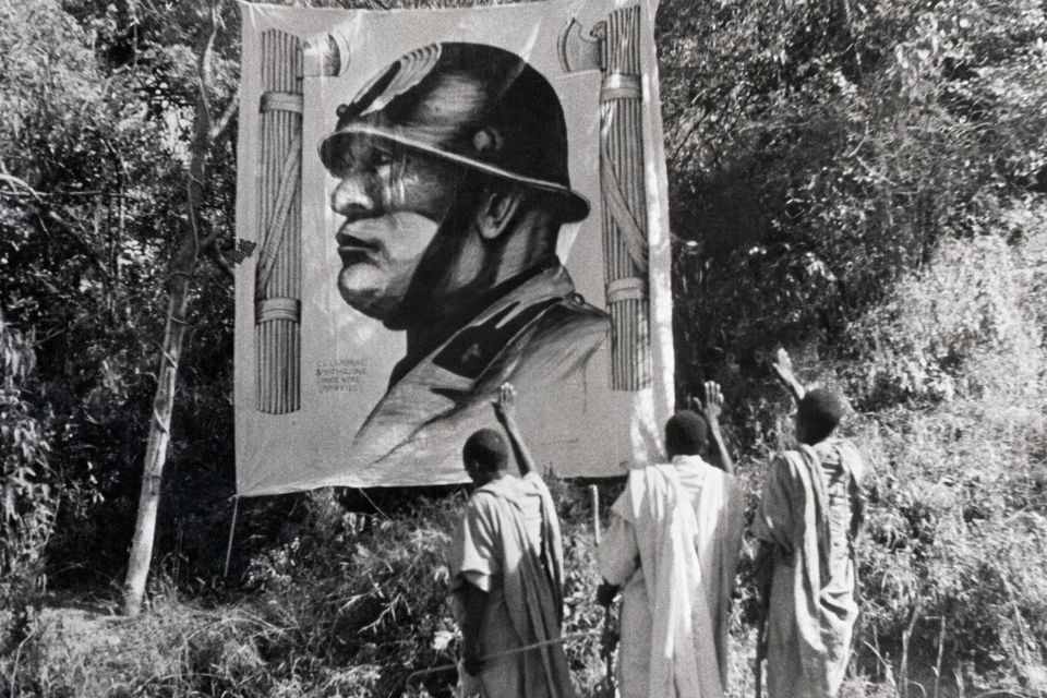 Ethiopians from the captured Tigre province pay their respects, Italian fashion, to a huge likeness of Benito Mussolini in 1934. Photo: Bettmann Archive