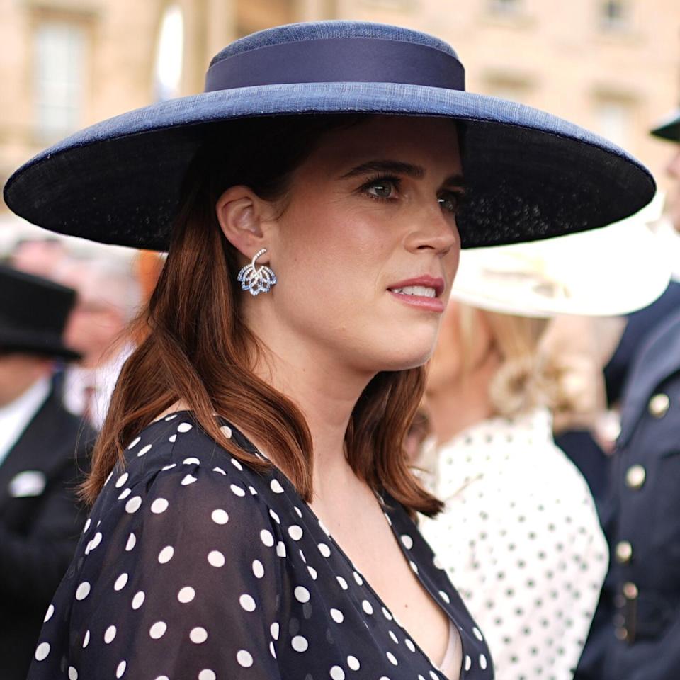 Princess Eugenie wearing a navy dress and hat.