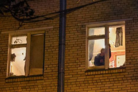 Mies korjasi rikkoutunutta ikkunaa Karshiskajan metroaseman vieressä sijaitsevassa asuintalossa tiistaiaamuna.