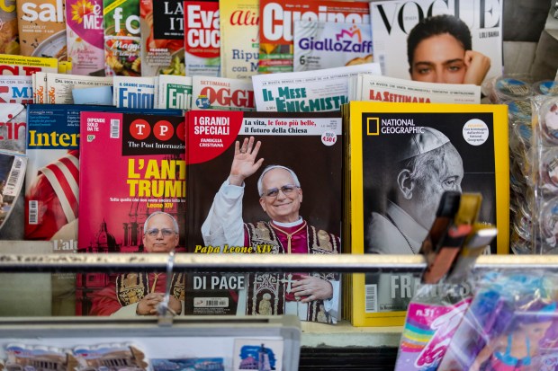 A newsstand shows covers featuring Pope Leo XIV and Pope...