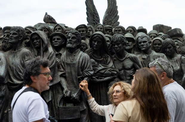 People visit a 2019 statue called "Angels Unawares” depicting 140...