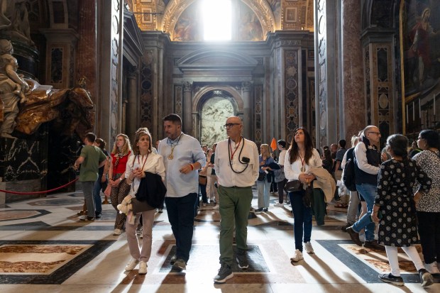 People visit St. Peter’s Basilica on May 15, 2025, before...