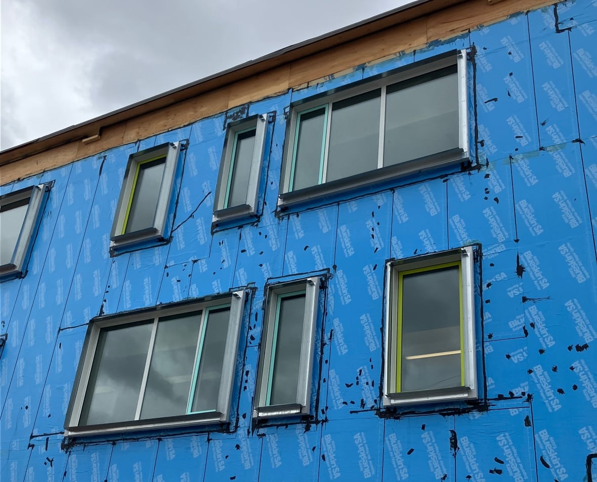 The face of a building that's under construction with new windows.