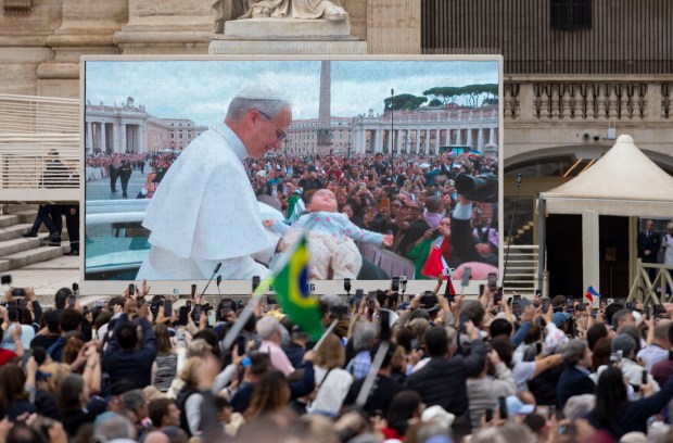 Pope Leo XIV blesses a baby while holding his first general audience on May 21, 2025, in St. Peter's Square at the Vatican. (Brian Cassella/Chicago Tribune)
