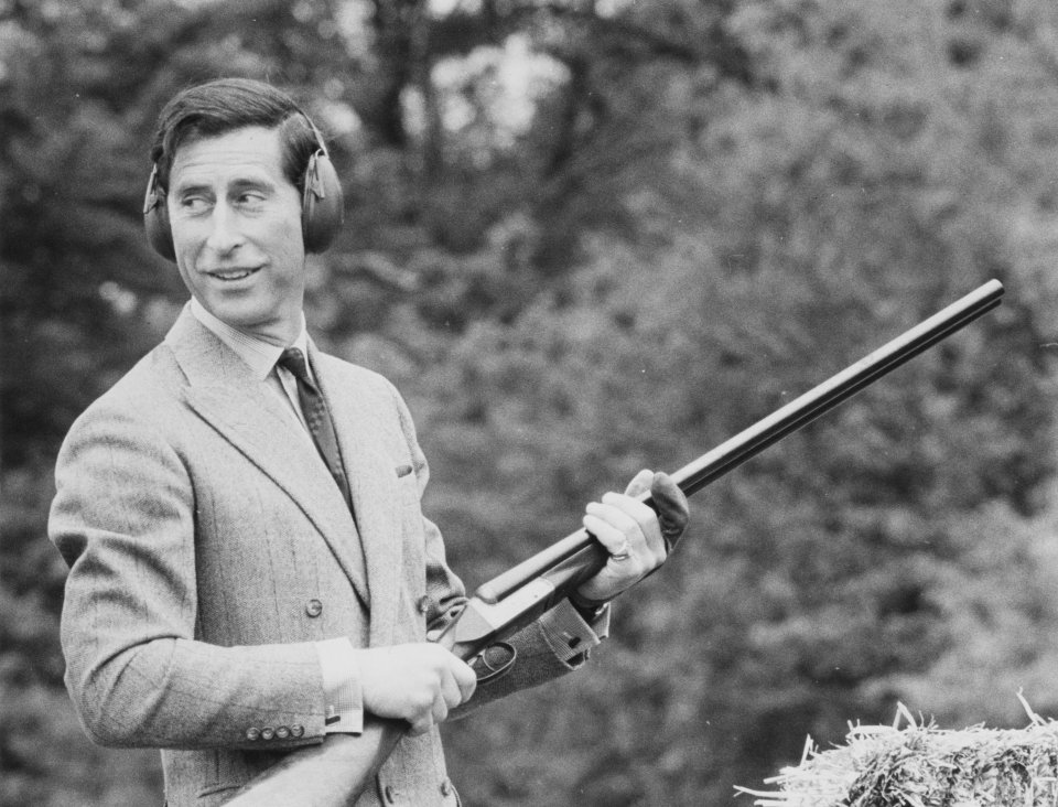 Prince Charles holding a shotgun at a shooting event.