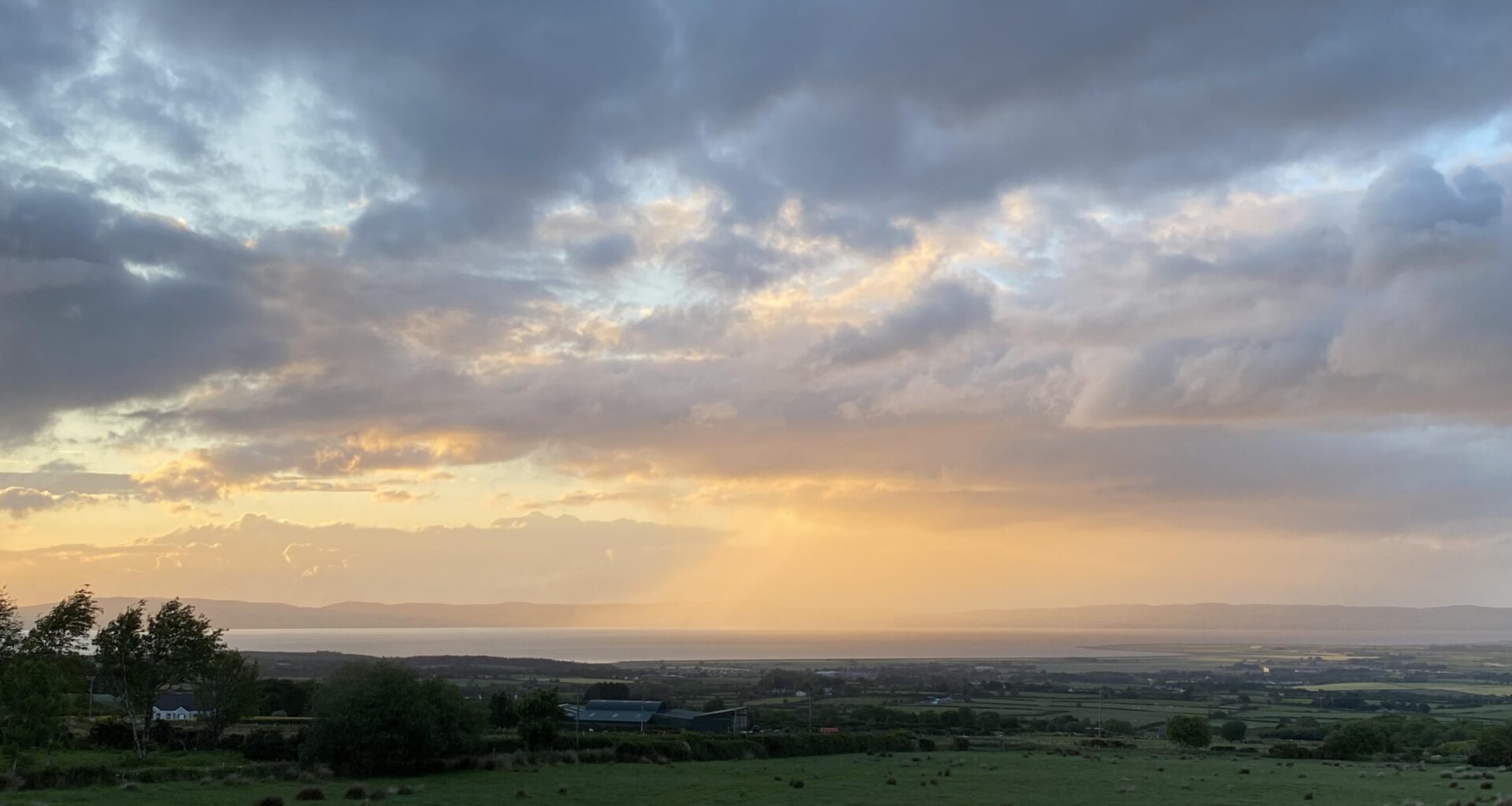 Sun lighting up the rain over the Foyle, clouds have been while dramatic looking all day