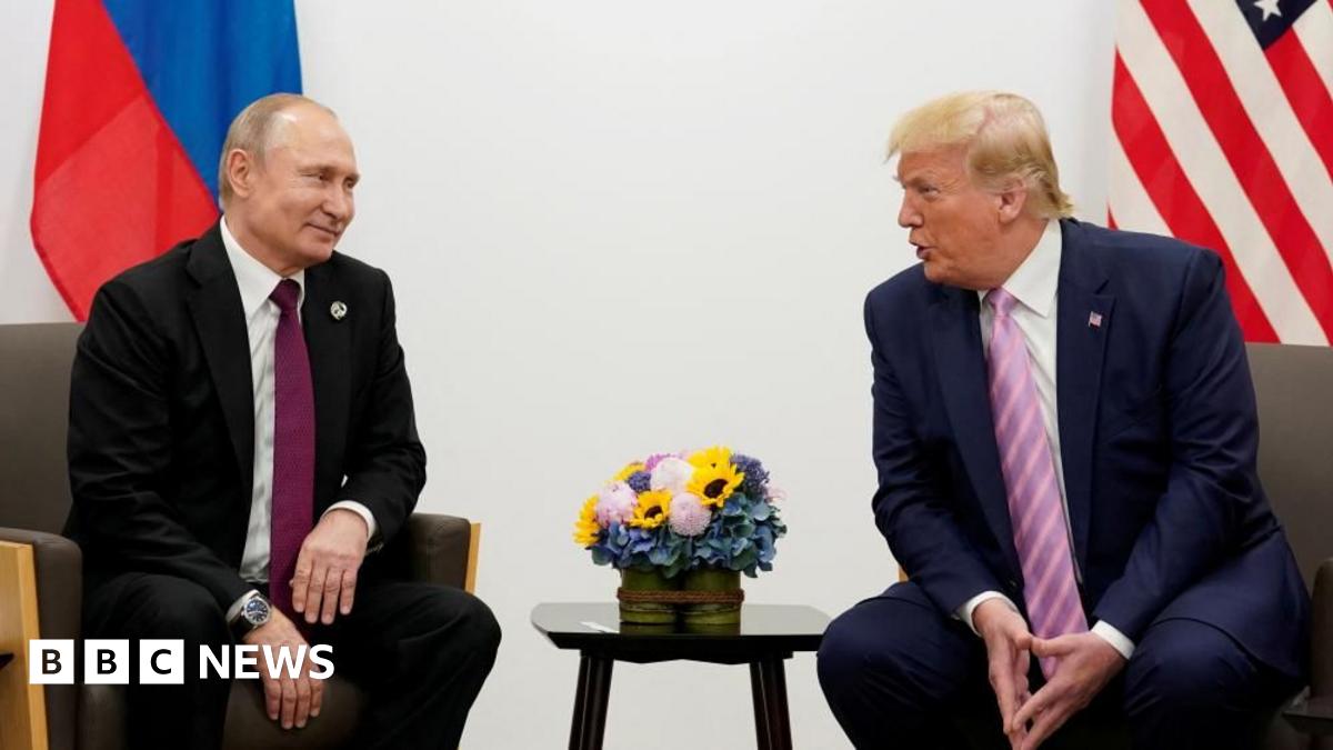 Trump and Putin sat on chairs, in suits, speaking to each other.