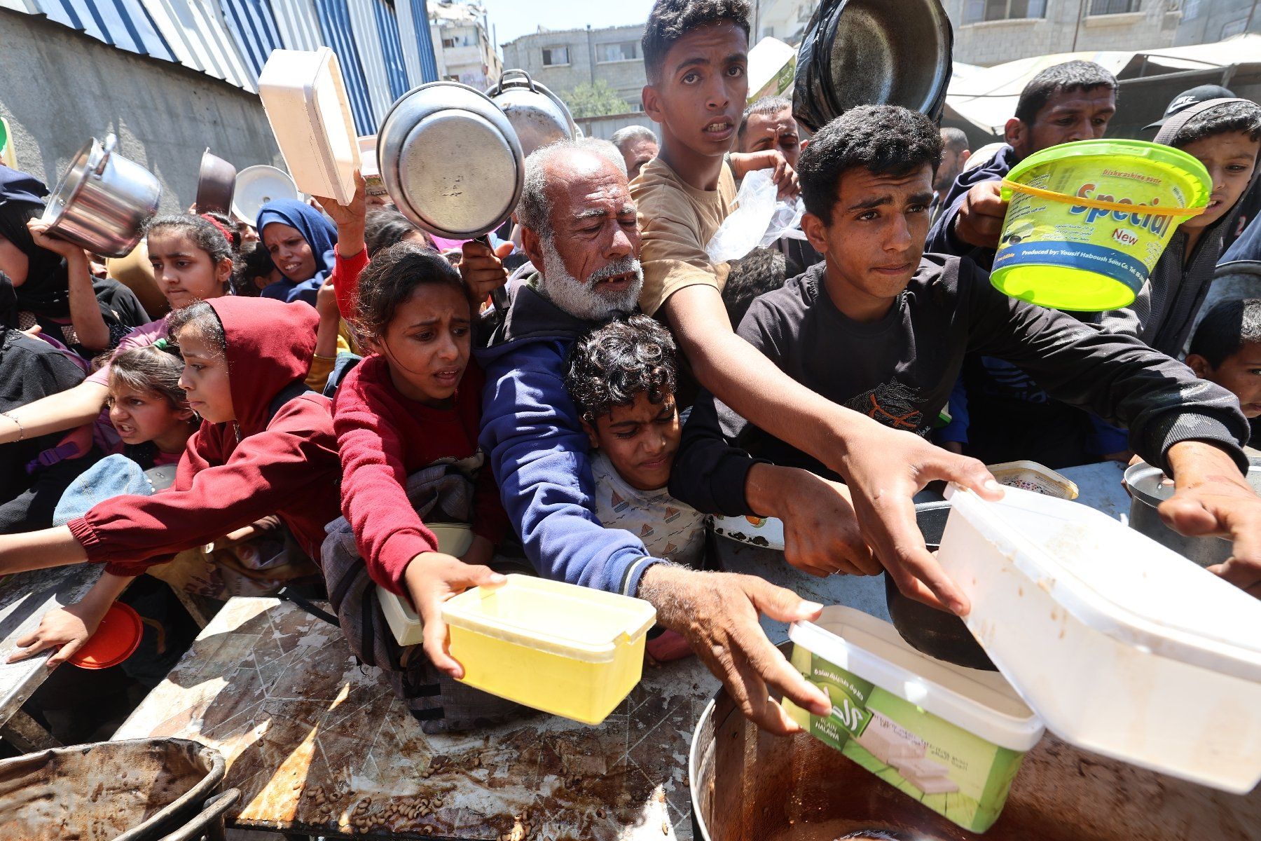 Des Palestiniens font la queue pour obtenir un repas chaud lors d'une distribution alimentaire au camp de réfugiés de Nousseirat, dans le centre de la bande de Gaza, le 4 mai 2025