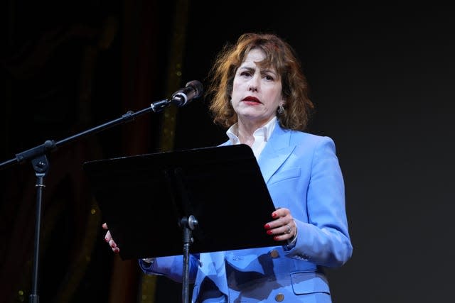 Victoria Atkins speaking from a lectern, wearing a blue suit