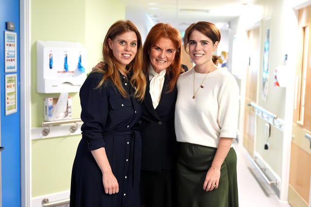Sarah, Duchess of York poses for a photo with her daughters Princess Beatrice and Princess Eugenie during a visit to the Teenage Cancer Trust unit at University College Hospital, London