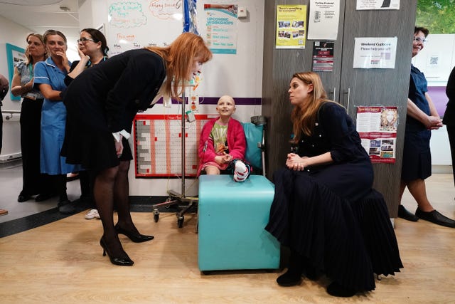 The Duchess of York and her daughter Princess Beatrice speak to a young cancer patient, Lola Belle Tucker, during a visit to the Teenage Cancer Trust unit at University College Hospital, London