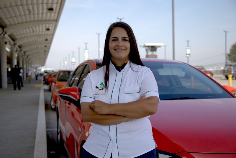 A woman standing beside a red car 