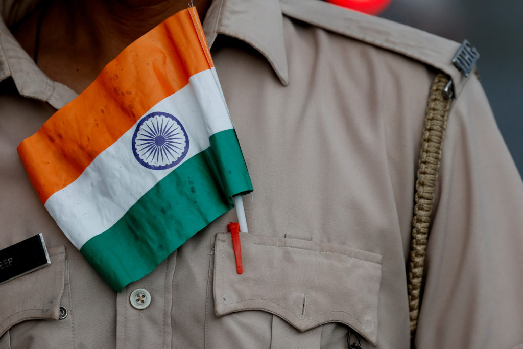 An Indian flag is pictured in the pocket of a police officer's uniform as he attends a rally in support of the Indian arme...