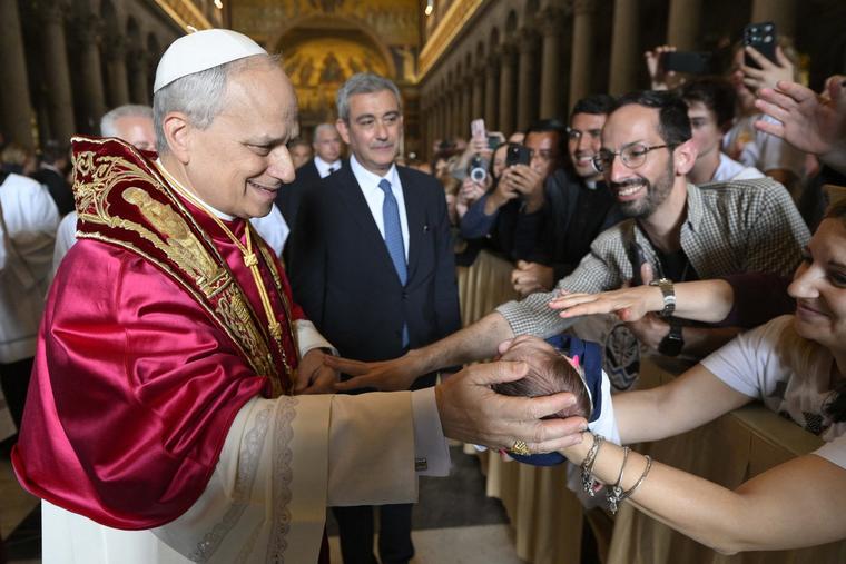 Pope Leo XIV blesses a baby during his May 20, 2025, visit to the Basilica of St. Paul Outside the Walls in Rome.