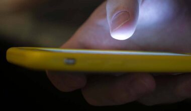 In a Sunday, Aug. 11, 2019, photo, a man uses a cell phone in New Orleans. (AP Photo/Jenny Kane)