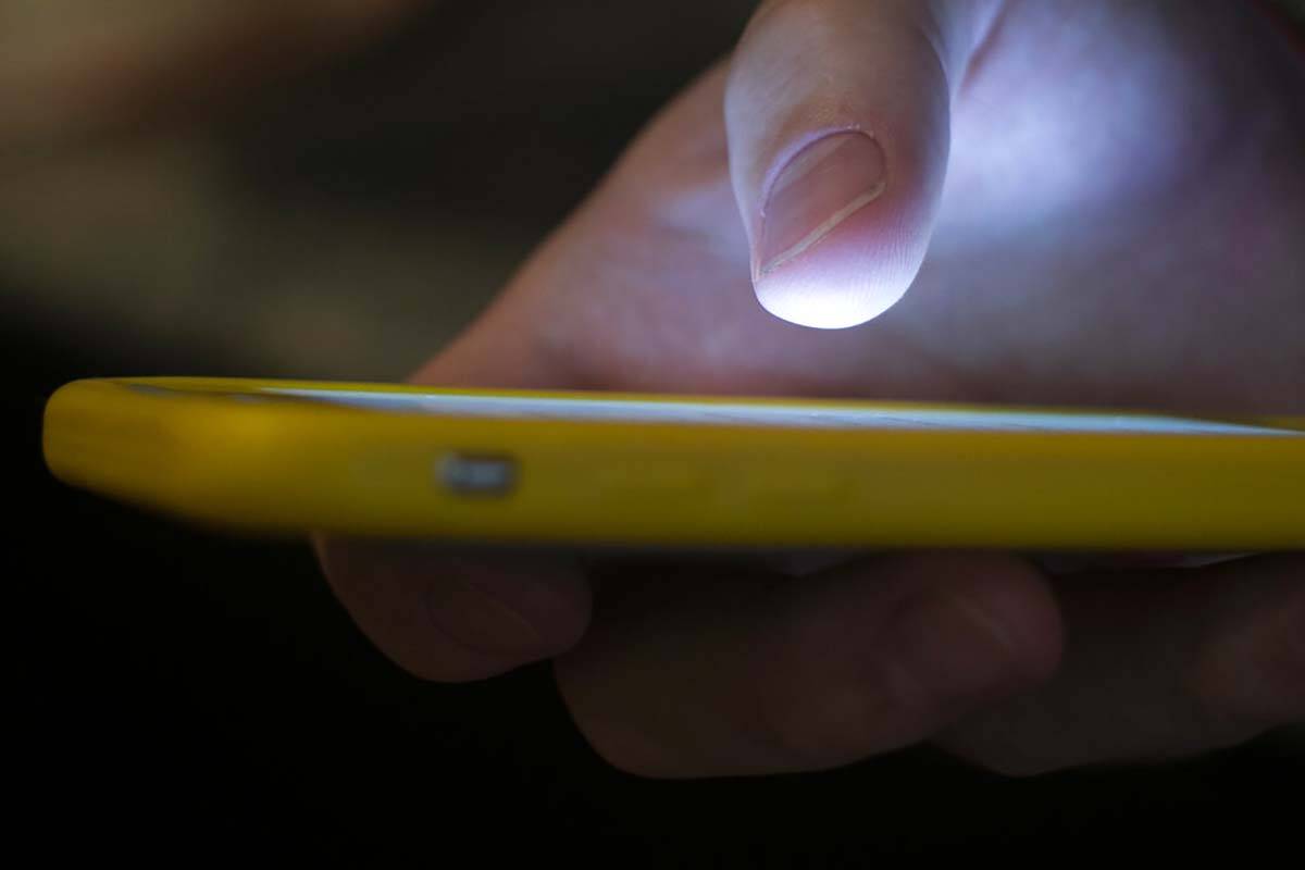 In a Sunday, Aug. 11, 2019, photo, a man uses a cell phone in New Orleans. (AP Photo/Jenny Kane)