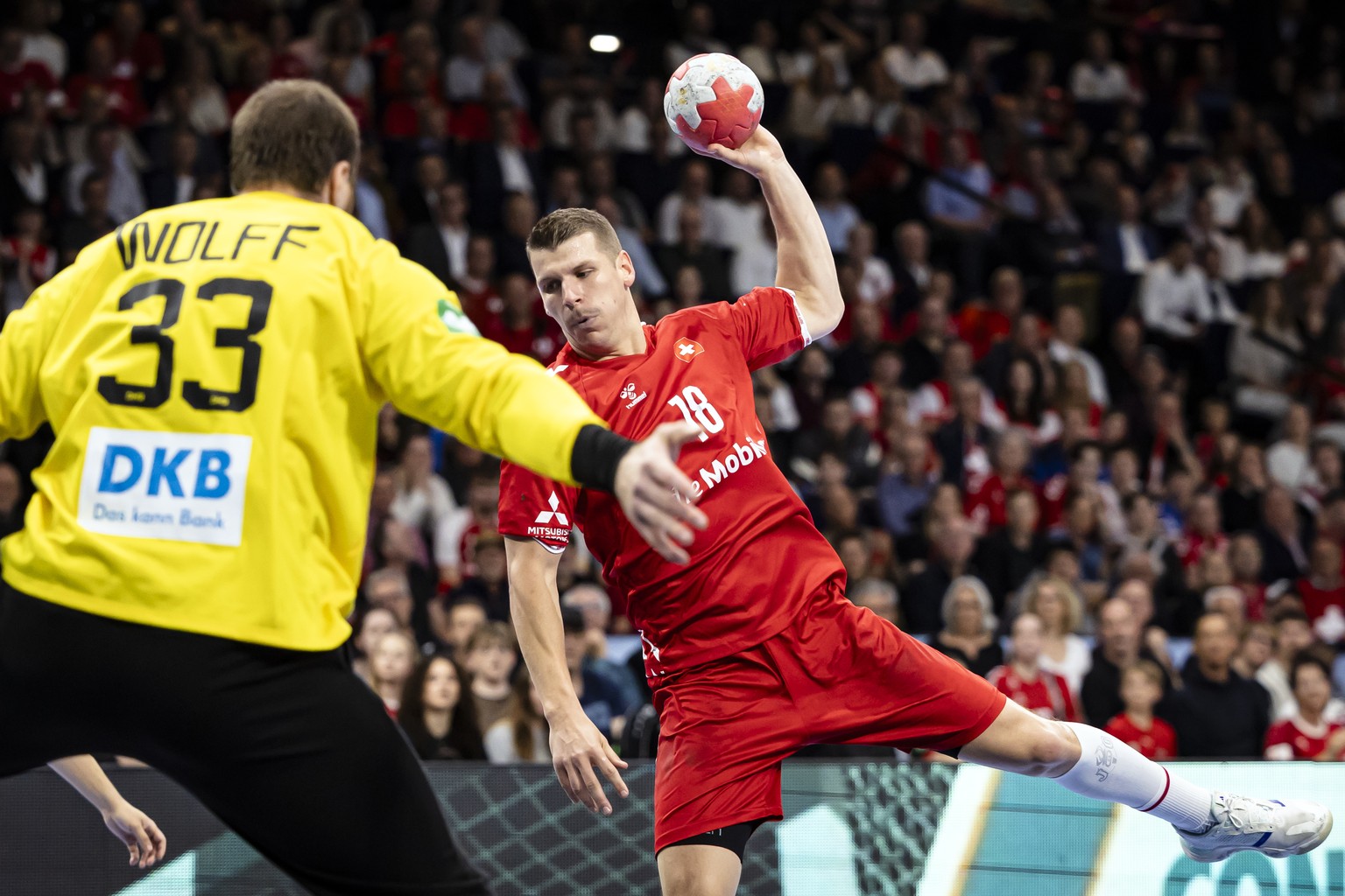 Switzerland's Dimitrij Kuettel, right, plays the ball against Germany's Goalkeeper Andreas Wolff, left, during the Men's EHF EURO 2026 Handball Qualifier game between Switzerland and Ge ...