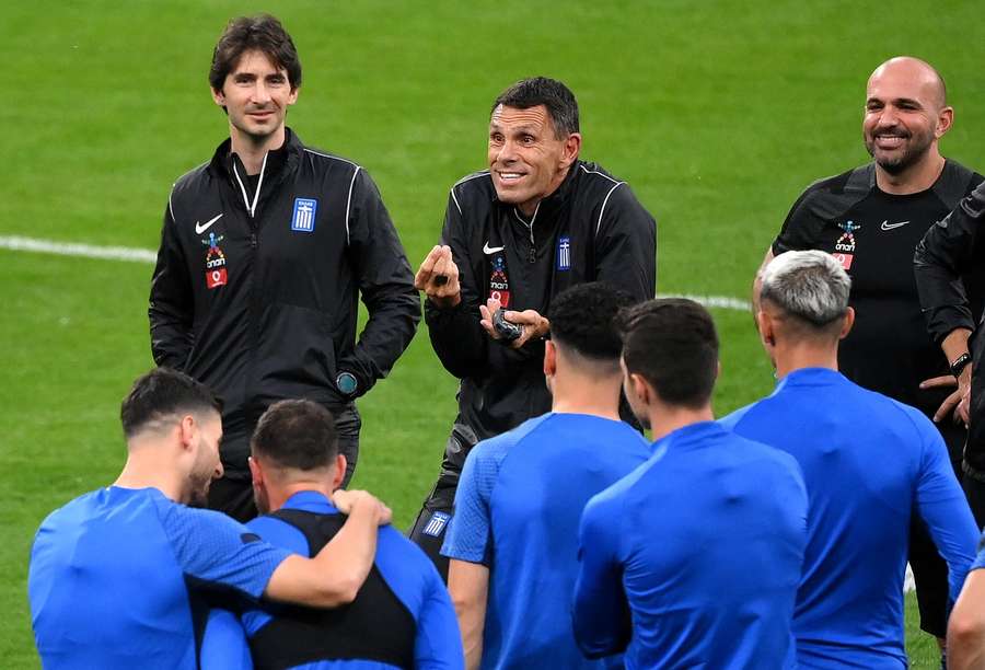 Poyet (centre) addresses his players during a training session while coach of Greece