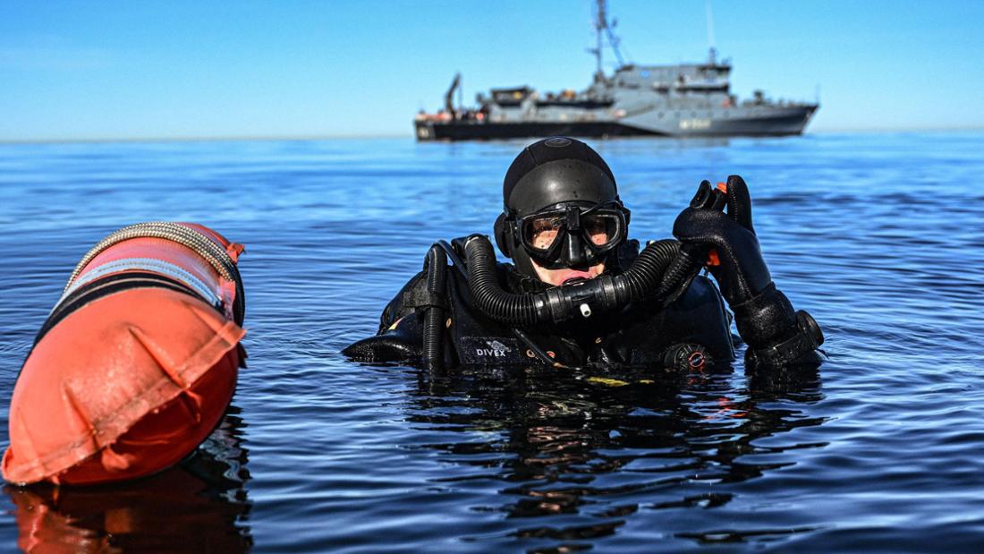 Taucher schwimmt vor Minensuchboot