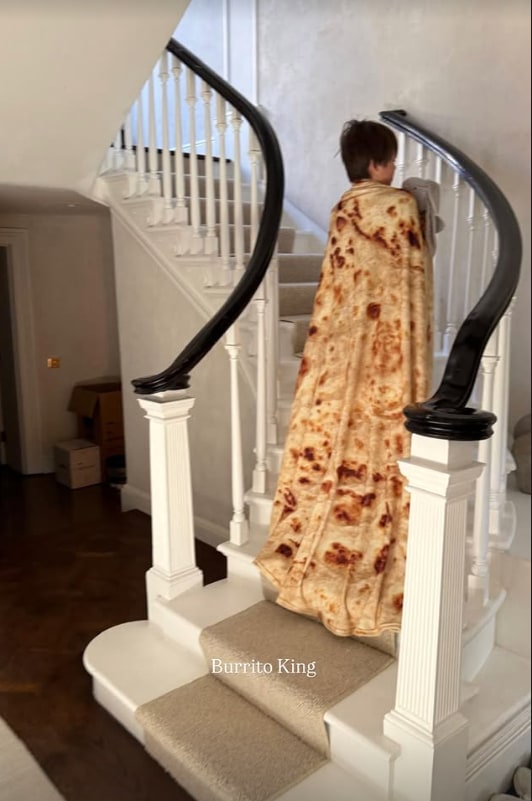 A photo of a boy wearing a burrito blanket 