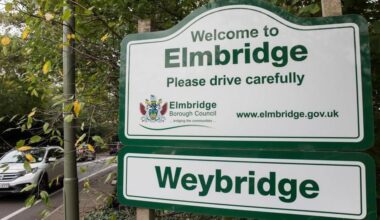 A sign for Elmbridge on the side of a road.