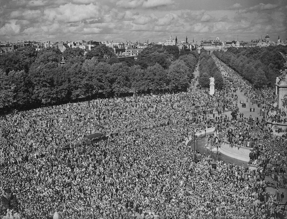 Crowds of people celebrating VJ Day, some climbing on the Victoria Memorial (to the right of the frame), on The Mall outside Buckingham Palace in Westminster, London, England, 15th August 1945. VJ Day (Victory over Japan Day) is the day Imperial Japan surrendered, bringing World War II to an end. (Photo by Central Press/Hulton Archive/Getty Images)