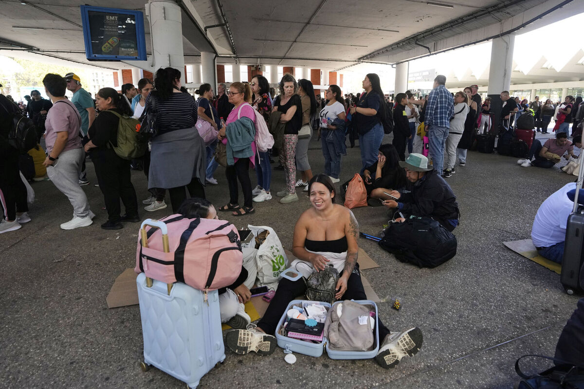 Passengers wait outside Atocha train station during a nationwide power outage in Madrid, Monday, April 28, 2025. (AP Photo/Manu Fernandez)