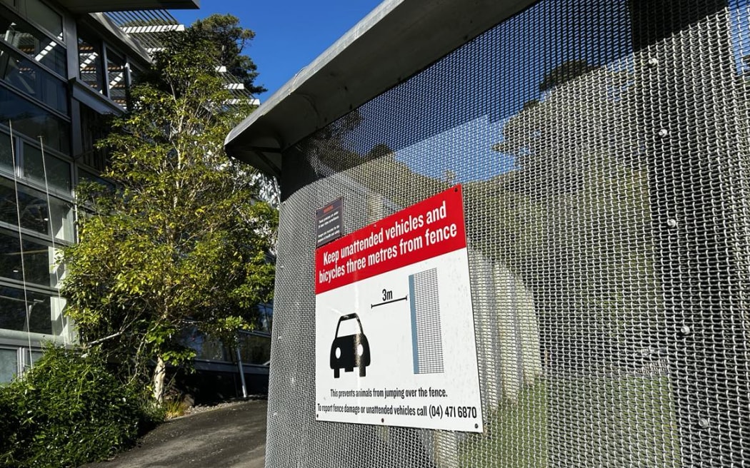 The fenceline is dotted with signs asking people not to inadvertently create a bridge for leaping predators.
