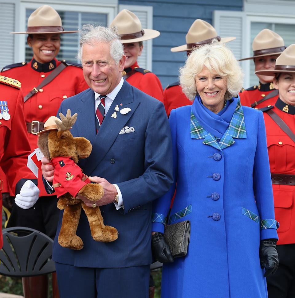 PICTOU, USA - MAY 19: Camilla, Duchess of Cornwall and Prince Charles, Prince of Wales are presented with a toy moose by the Royal Canadian Mounted Police on May 19, 2014 in Pictou, Canada. The Prince of Wales and Duchess of Cornwall are on a four day visit to Canada. (Photo by Chris Jackson/Getty Images)