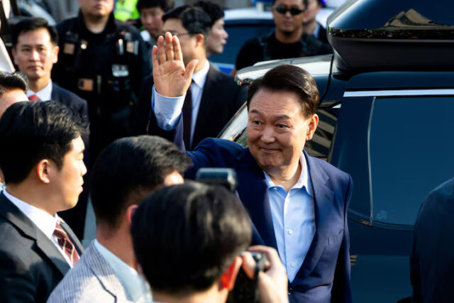 Ousted former South Korean President Yoon Suk Yeol waves to his supporters as he moves out of the presidential residence in Seoul, South Korea, April 11, 2025. Yonhap/via REUTERS/File Photo