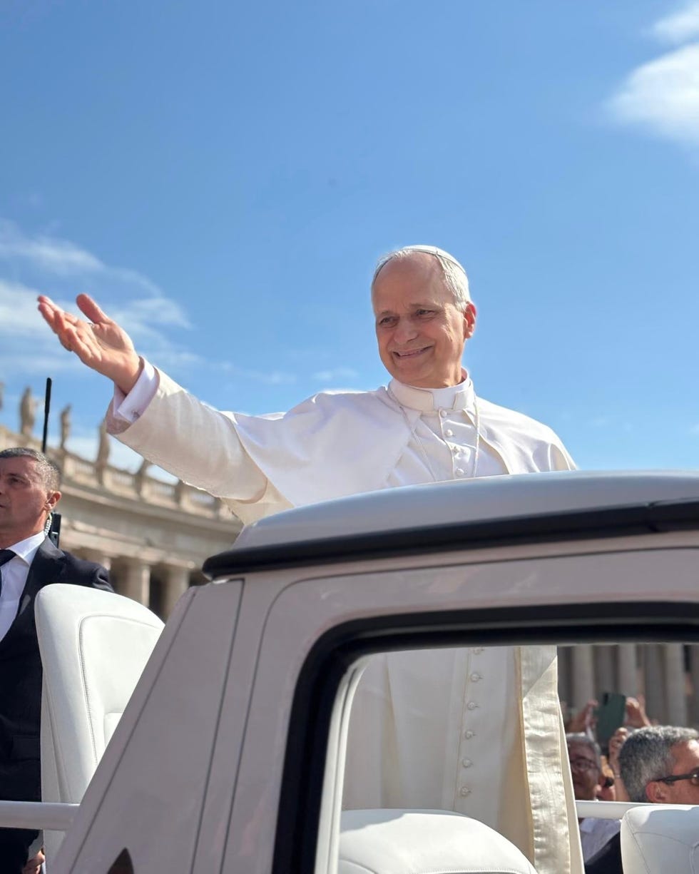 pope greeting crowds from a vehicle in vatican city