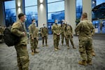FILE - Oregon National Guard members wait for training before the start of the vaccination clinic being held at the Oregon Convention Center, Jan. 27, 2021.