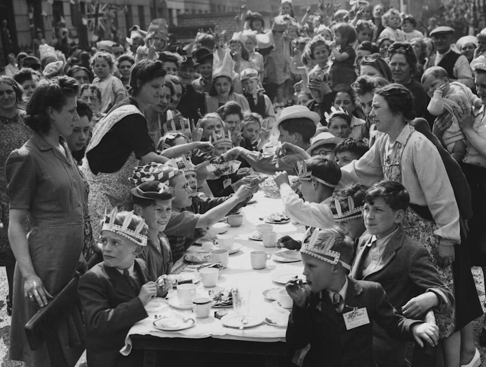 Islington residents have a tea party in the street on May 21, 1945 to celebrate the first Whitsunday (Pentecost) of peacetime. (Photo by © Hulton-Deutsch Collection/CORBIS/Corbis via Getty Images)