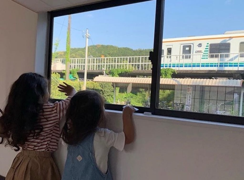 Two young guests at Inn My Life, a lodging in a disused part of unstaffed Futamata-Hommachi Station in Shizuoka prefecture, wave at a passing train. Photo: Instagram/inn_my_life Two young guests at Inn My Life, a lodging in a disused part of unstaffed Futamata-Hommachi Station in Shizuoka prefecture, wave at a passing train. Photo: Instagram/inn_my_life