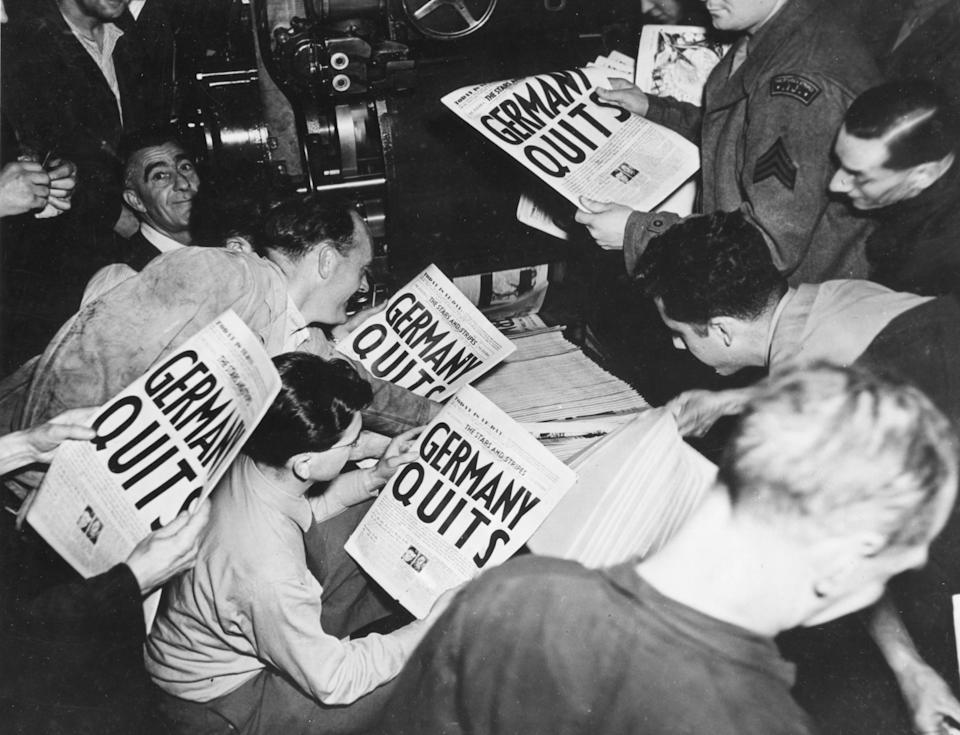 Allied soldiers and others read copies of the Stars and Stripes military newspaper, off the press (belonging to the London Times), that announces Germany's surrender in World War II, London, England, May 7, 1945. (Photo by U S Signal Corps/PhotoQuest/Getty Images)