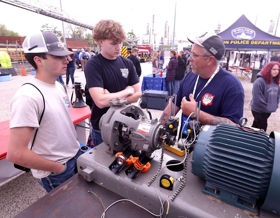 Landon Hannah, left, and Beau Mitchell, both juniors at Buckeye Career Center, chat with Marathon Petroleum mechanical technician Jeremy Toole at a station at Career Day at Marathon's Canton site.