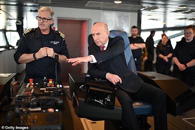 Britain's Defence Secretary John Healey (R) talks to Commanding Officer of RFA Proteus, Captain Martin Jones (L) as he sits at the dynamic positioning desk on the bridge during his visit to RFA Proteus on February 20, 2025