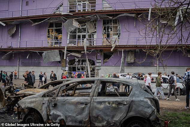 Russia and Ukraine are at odds over competing ceasefire proposals. Ukrainian President Volodymyr Zelensky said a ceasefire is possible 'even from today' if Moscow is serious about ending the war. Pictured: People gather at the site of a Russian drone strike on the Obolonskyi district on May 4