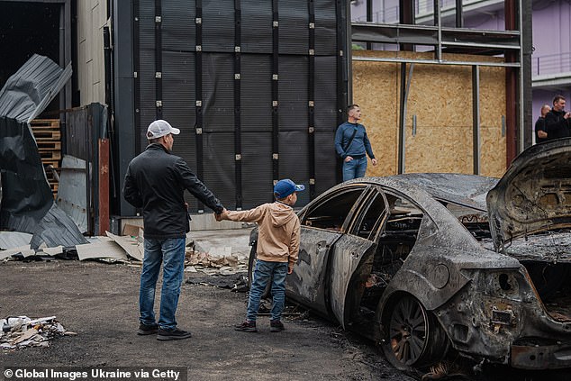 Speaking on Sunday at a joint news conference with Czech President Petr Pavel, Zelensky noted that Russia has ignored a US proposal for a full ceasefire for 54 days and thanked the Czech Republic for backing Ukraine's call for a 30-day ceasefire. Pictured: A boy, walking with his father past the site of a Russian drone strike in Kyiv on May 4