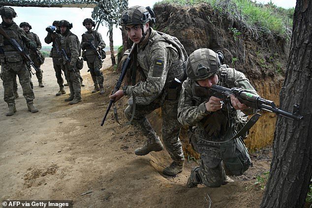 Putin signed a revamped version of Russia's nuclear doctrine in November, spelling out the circumstances that would allow him to use the world's largest atomic arsenal. Pictured: Young members of the 28th Separate Mechanized Brigade take part in a tactical field training exercise