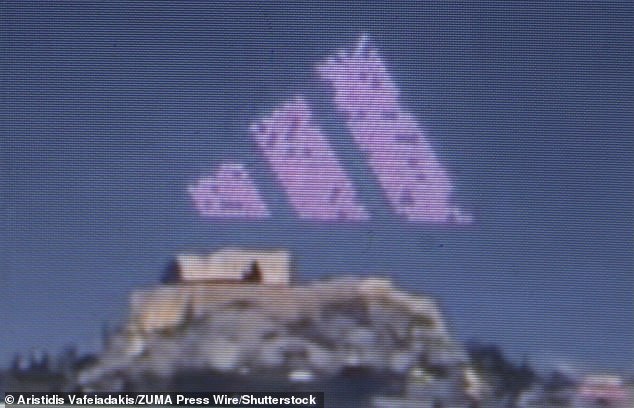 The instantly recognisable Adidas logo lights up the sky above the Acropolis