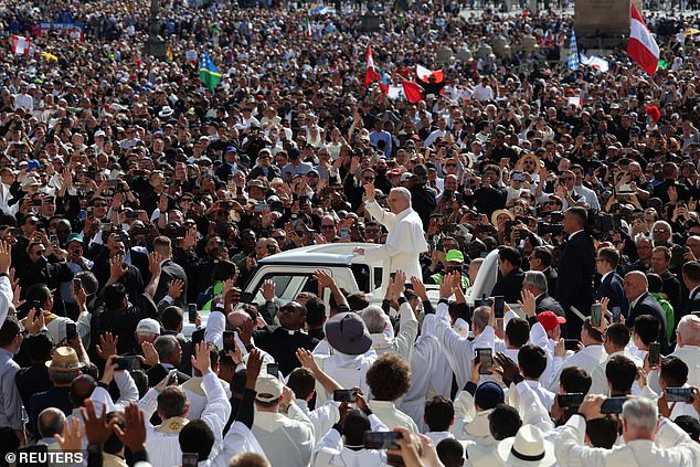 Pope Leo XIV waves to the masses as he rides through the piazza on the popemobile